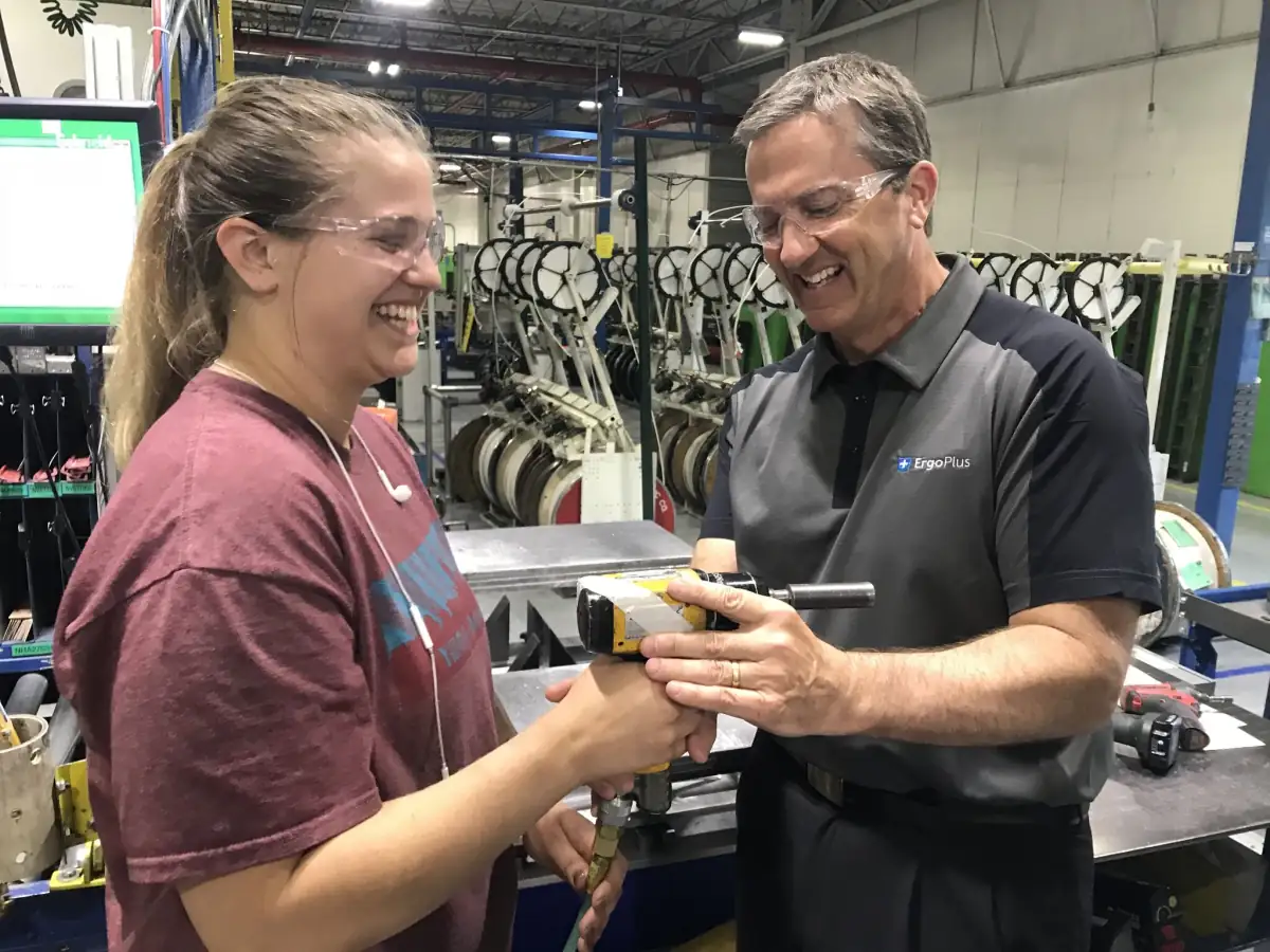 An ErgoPlus injury prevention specialist working with an employee on the plant floor